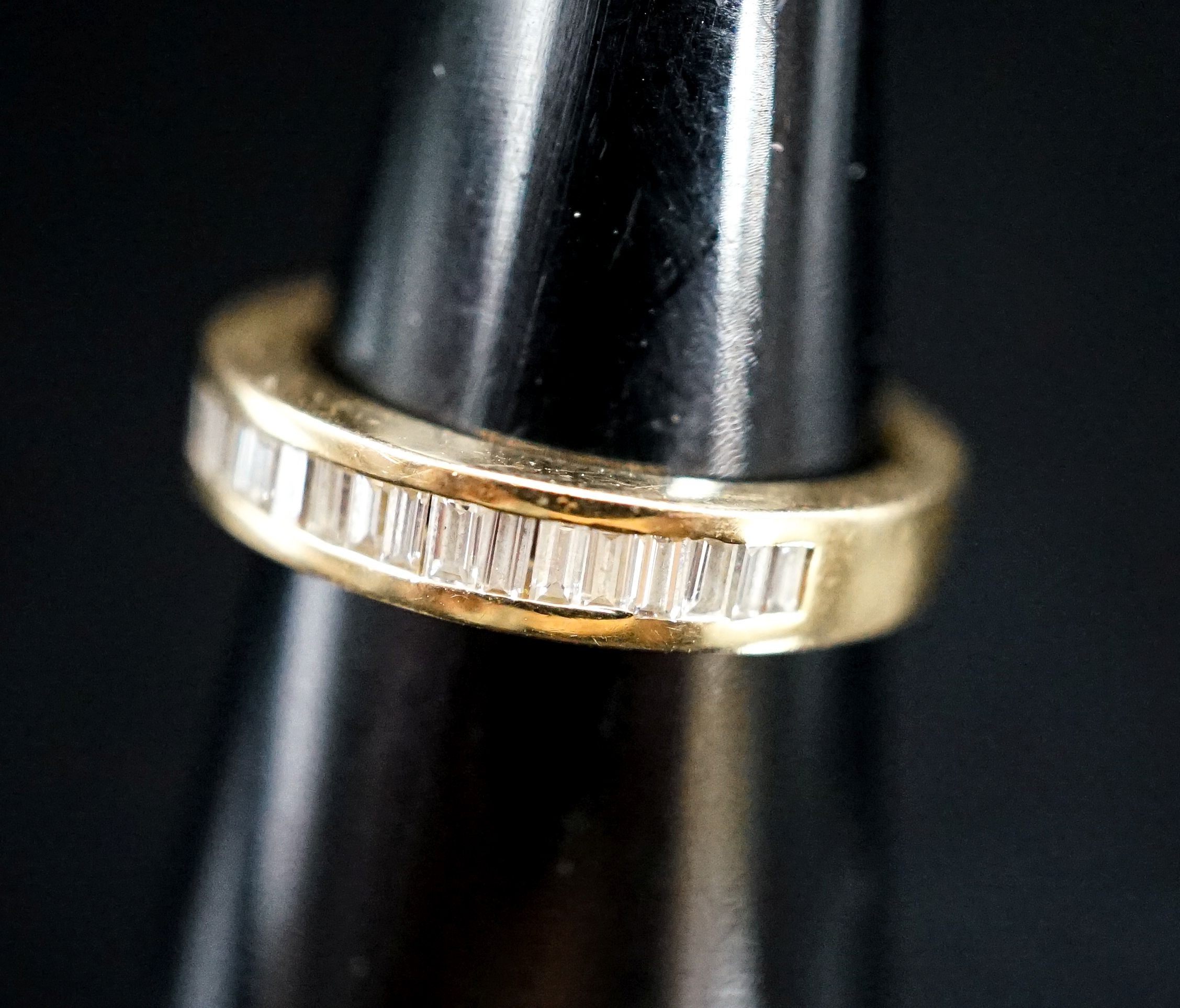 A continental 750 yellow metal and baguette cut diamond set half eternity ring, size L, gross 5.1 grams.